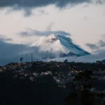 town with lights far from mountain field with snow